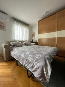 Schlafzimmer mit einem großen Bett mit einem Kopfteil aus Holz in der Unterkunft Lanište - Prelijep stan, balkon, wifi + besplatan parking in Zagreb