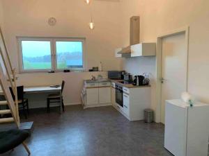 a kitchen with a desk and a table in it at Moderne Maisonettewohnung/2 Zimmer/Küche/Bad #1 in Markt Schwaben +8 photos