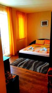 a bedroom with a bed with orange walls and a window at Къща за гости Вълчеви Несебър in Nesebar