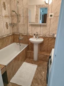 een badkamer met een wastafel, een douche en een bad bij Apartament Szpitalna in Suwałki