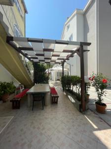 a patio with a table and benches under awning at Apartmani Roko&Lovre Paklenica in Starigrad