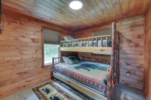 a bedroom with a bunk bed in a log cabin at Cozy Ellicottville Cabin with Water Views - Near Ski in Ellicottville