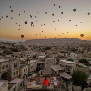 um grupo de balões de ar quente sobrevoando uma cidade em Angel View Suites em Goreme