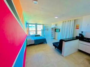 a room with a bed and a colorful wall at LOFT ORLA PRAIA GRANDE até 5 pessoas in Arraial do Cabo