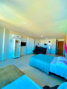 ein großes Schlafzimmer mit 2 Betten und einem Sofa in der Unterkunft LOFT ORLA PRAIA GRANDE até 5 pessoas in Arraial do Cabo