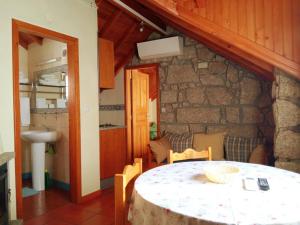 a dining room with a table and a stone wall at Casas do Cruzeiro in Sabugueiro +170 photos