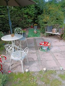 una mesa, sillas y una sombrilla en un patio en The White Dove Bed and Breakfast and Bell Tents 1 en Newark upon Trent
