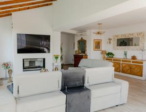 a living room with white furniture and a tv at Villa Esmeralda in Altea la Vieja