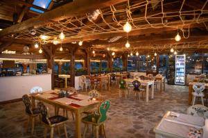 a restaurant with tables and chairs in a room at Due Fratelli Village Resort in Şinteu