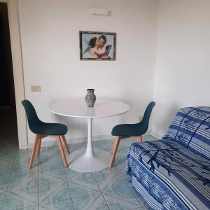 1 mesa y 2 sillas en una habitación con 1 cama en "CASA SUNSET" en Ischia