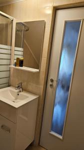 La salle de bains est pourvue d'un lavabo, d'un miroir et d'une porte. dans l'établissement Fantastic camp, à Piteşti