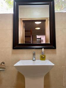 a white sink in a bathroom with a mirror at LA SUNSET in Accra