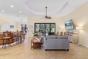 sala de estar con sofá y mesa en Gulf access, Heated Pool, outdoor kitchen, firepit & dock - Waterfront Paradise, en Cabo Coral
