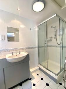a bathroom with a sink and a glass shower at The Egerton Arms Astbury in Congleton