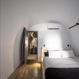 um quarto com uma cama e um corredor em Pyrgos Cave Suites em Pírgos