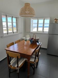 uma cozinha com uma mesa de madeira e algumas janelas em Casa do Paúl em Santa Cruz da Graciosa
