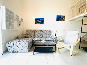 sala de estar con sofá y silla en Corso 34, en Porto Santo Stefano