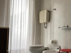 uma casa de banho com um WC branco e um lavatório. em Appartamenti Nataly em Nago-Torbole