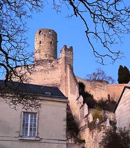 un castillo con una torre en la parte superior de un edificio en Le gargantua, appartement à 500m du château, en Chinon