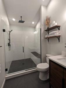 a bathroom with a shower and a toilet and a sink at Base Camp in Cortland