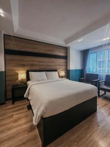 a bedroom with a large bed with a wooden headboard at The Chill Suites - City Center in Ho Chi Minh City