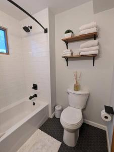 a bathroom with a toilet and a tub and a sink at Base Camp in Cortland