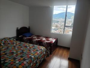 1 Schlafzimmer mit 2 Betten und einem großen Fenster in der Unterkunft Apartamento amoblado con excelente ubicación en Pasto in Pasto