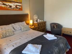 a bedroom with a large bed with two towels on it at The Wighthill in Sandown