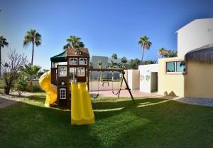 een speeltuin met een glijbaan en een huis bij Zona Hotelera San José del Cabo in San José del Cabo