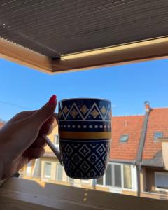 a person holding a coffee cup in a window at Paradise in Brčko