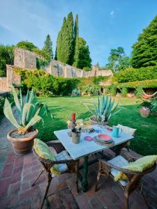 ein Tisch und Stühle auf einer Terrasse mit Pflanzen in der Unterkunft Charming cottage only for you, a hidden gem 10mn walk to historic center, stunning view in Florenz