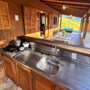 a kitchen with a stainless steel sink and a stove at Recanto Paraíso da Colina in Santo Amaro da Imperatriz