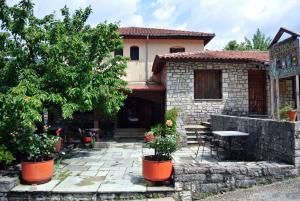 a house with a patio and a table and trees at 4Epoches in Ayía Triás