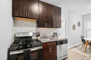 eine Küche mit Herd und Spüle in der Unterkunft Chic & Fully Furnished Studio Apt with Laundry - Brompton 61-66 rep in Chicago