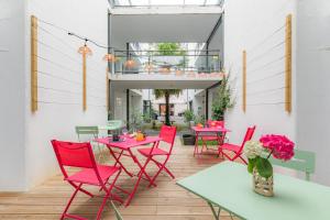 a patio with red chairs and tables and a balcony at Appart'City Confort Pau Centre in Pau