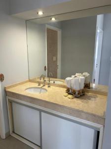 eine Badezimmertheke mit einem Waschbecken und einem Spiegel in der Unterkunft DEPARTAMENTO DEL PASEO in Bahía Blanca
