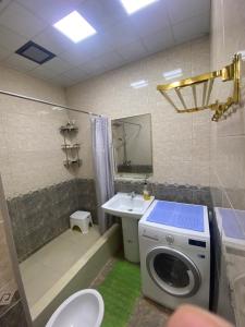 een badkamer met een wasmachine en een wastafel bij Park Istiklol in Doesjanbe