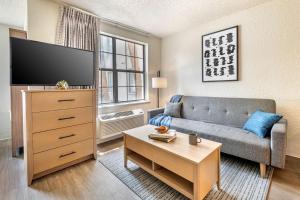 sala de estar con sofá y TV en InTown Suites Extended Stay Orlando FL – Presidents Dr en Orlando