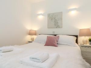 コニストンにあるWatersongのタオルが敷かれた白いベッドのある寝室
