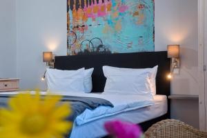 Schlafzimmer mit einem Bett mit Wandgemälde in der Unterkunft Maritas Logierhaus (Haus Braunschweig) in Westerland
