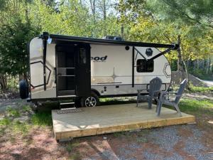 a trailer with a bench and a chair on a wooden platform at Dominion Hill Country Inn in Bocabec