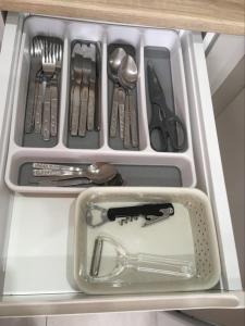 a drawer filled with utensils in a cabinet at Apartament Centrum in Suwałki