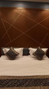 a bed with a wooden headboard and two pillows at شقق فاتوران الفاخره in Al Madinah