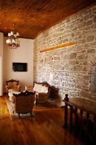 uma sala de estar com uma parede de pedra e cadeiras em Hera Hotel em Bergama