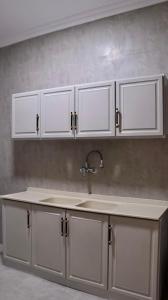 a kitchen with white cabinets and a sink at شقق فاتوران الفاخره in Al Madinah