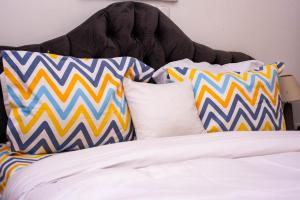 a bed with colorful pillows on top of it at Appartement Cosy 3 bonapriso in Douala