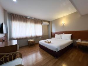 una camera d'albergo con letto e TV di Srivichai Hotel a Nakhon Ratchasima