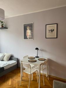 a living room with a table and chairs and a bed at Night Host Matejki 4 in Bytom