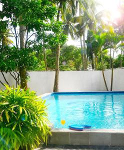- une piscine avec 2 chaises longues à côté d'un mur dans l'établissement Calm Villa Wadduwa, à Wadduwa