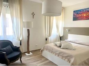 a bedroom with a bed and a blue chair at COROS - AFFITTI BREVI FUCECCHIO in Fucecchio